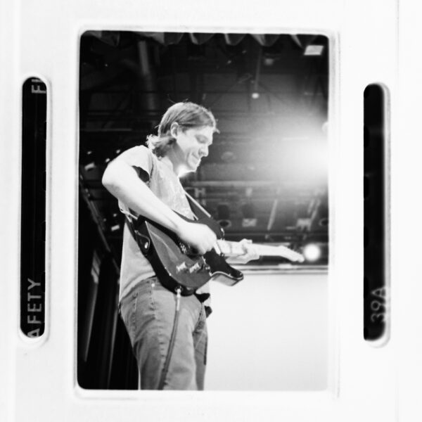 Man playing guitar on stage with bright lights